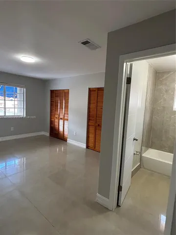 an empty room with windows and closet