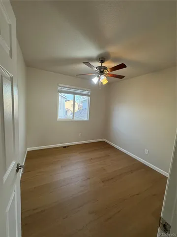 a view of an empty room with a chandelier fan