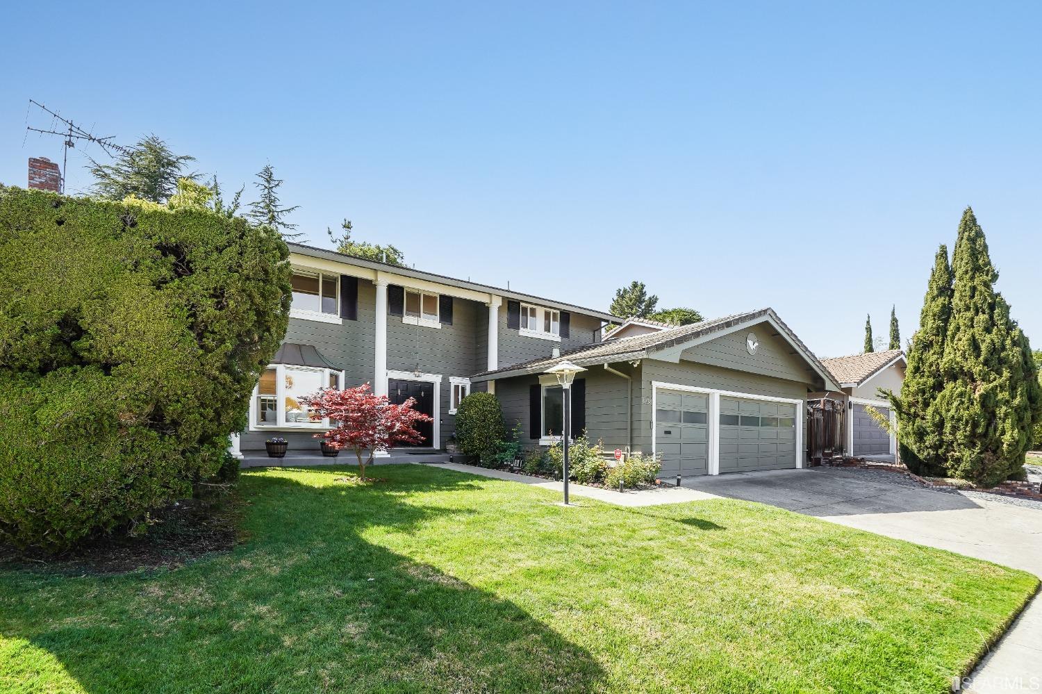 a front view of a house with a yard and potted plants