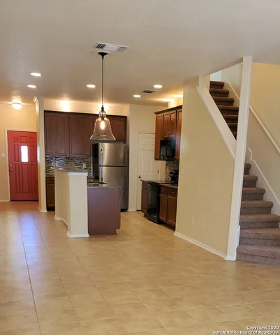 a kitchen with stainless steel appliances granite countertop a refrigerator and a sink
