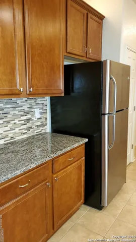 a kitchen with stainless steel appliances granite countertop a refrigerator a stove and a sink