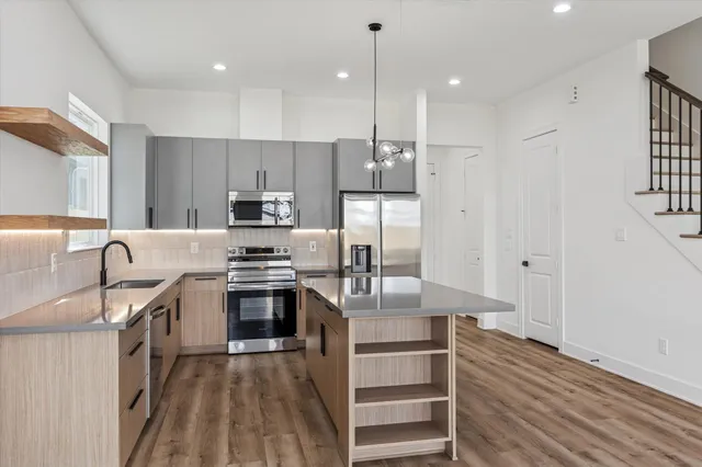 a kitchen with stainless steel appliances granite countertop a sink stove and refrigerator