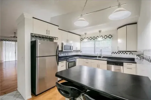 a kitchen with a refrigerator a sink and cabinets
