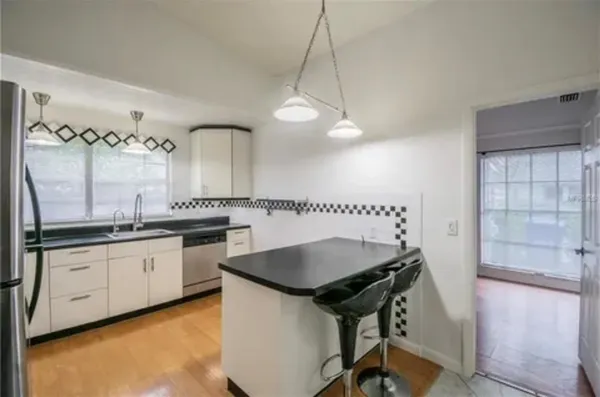 a kitchen with granite countertop a sink a stove and a wooden floor