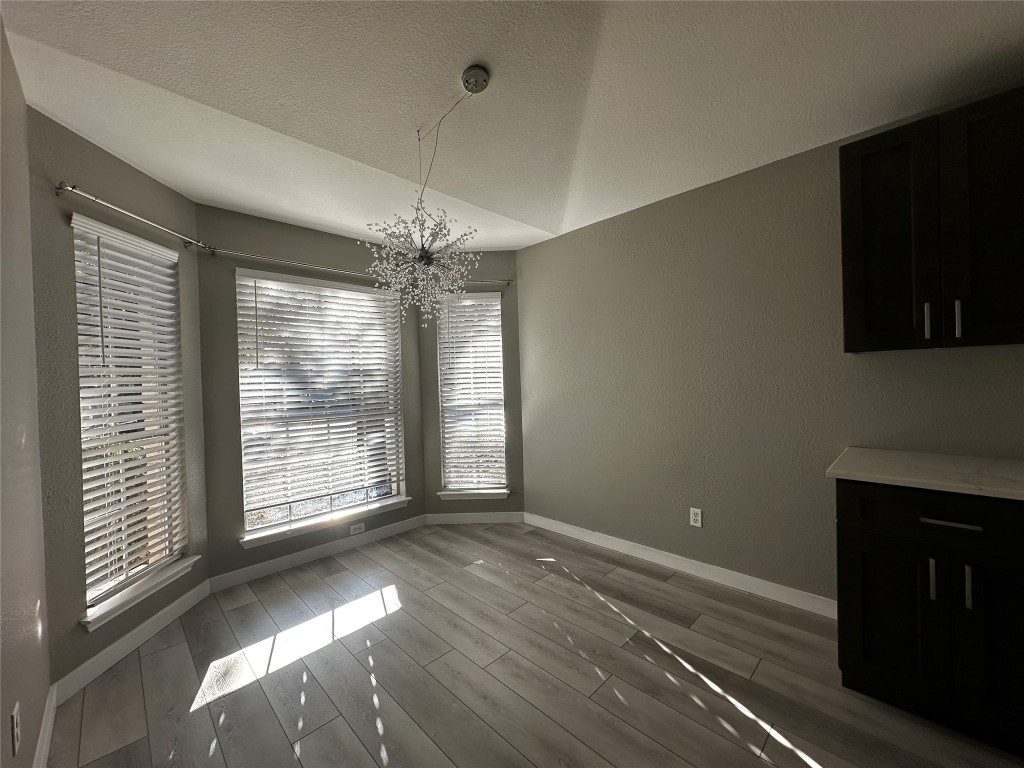 17733 Loch Linnhe Loop Pflugerville, TX 78660 - Photo 3 of 16 a view of an empty room with wooden floor and a window