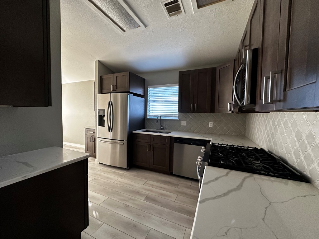 17733 Loch Linnhe Loop Pflugerville, TX 78660 - Photo 6 of 16 a kitchen with granite countertop a refrigerator and a stove top oven