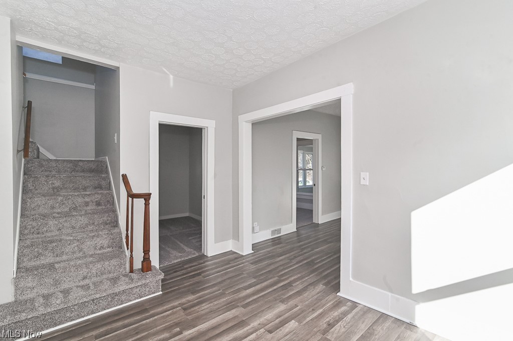 6469 Red Brush Road Ravenna, OH 44266 - Photo 13 of 34 Hall featuring dark wood-type flooring and a textured ceiling