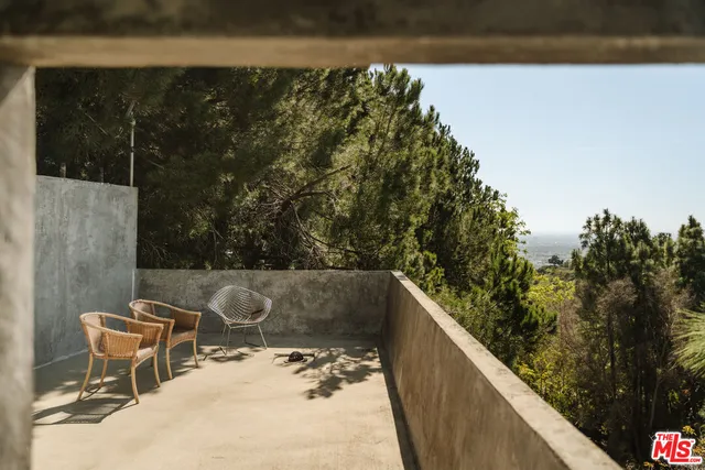 an aerial view of a house with swimming pool and large trees