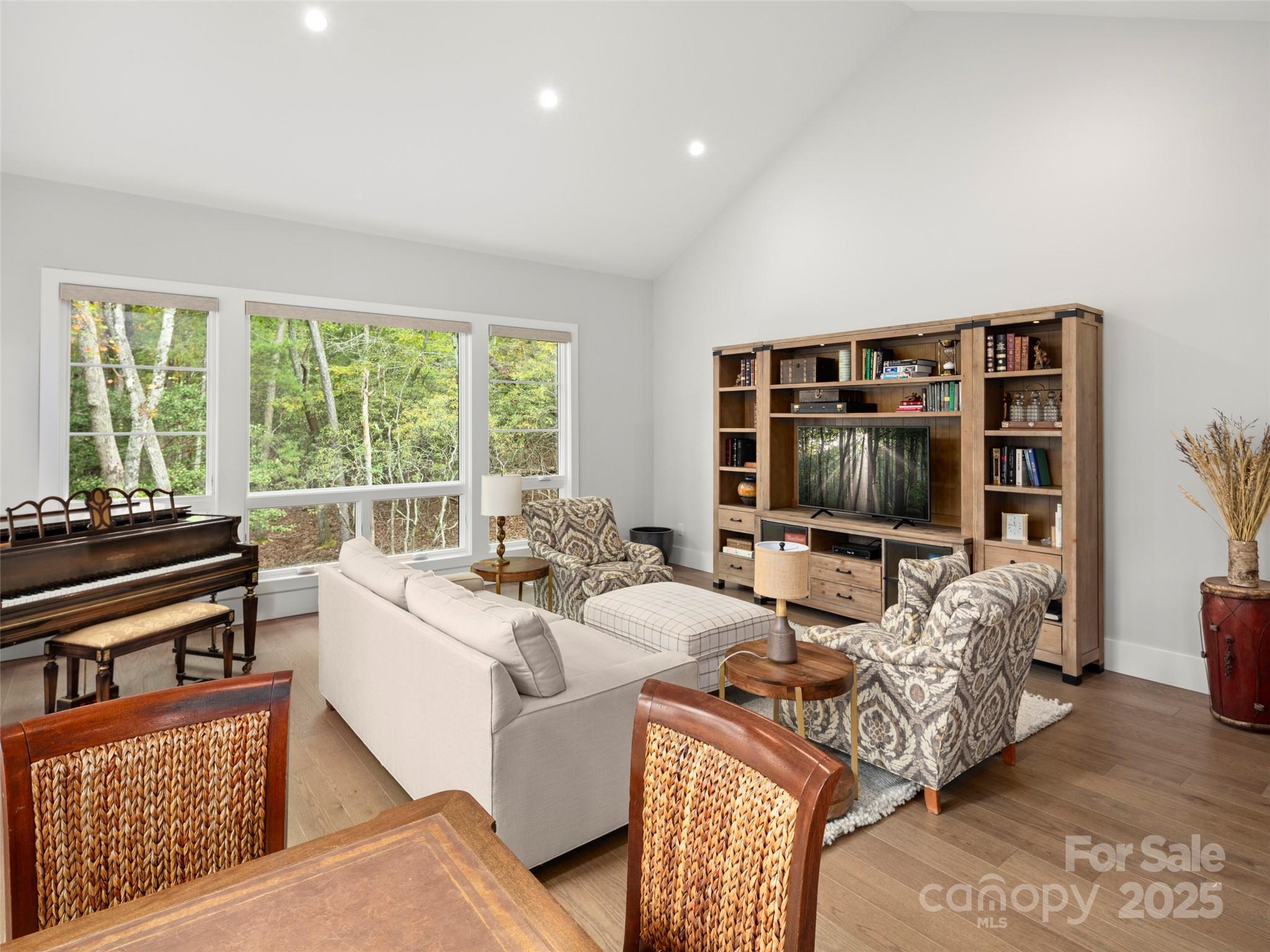 1565 Country View Way Arden, NC 28704 - Photo 14 of 31 a living room with furniture a flat screen tv and a floor to ceiling window