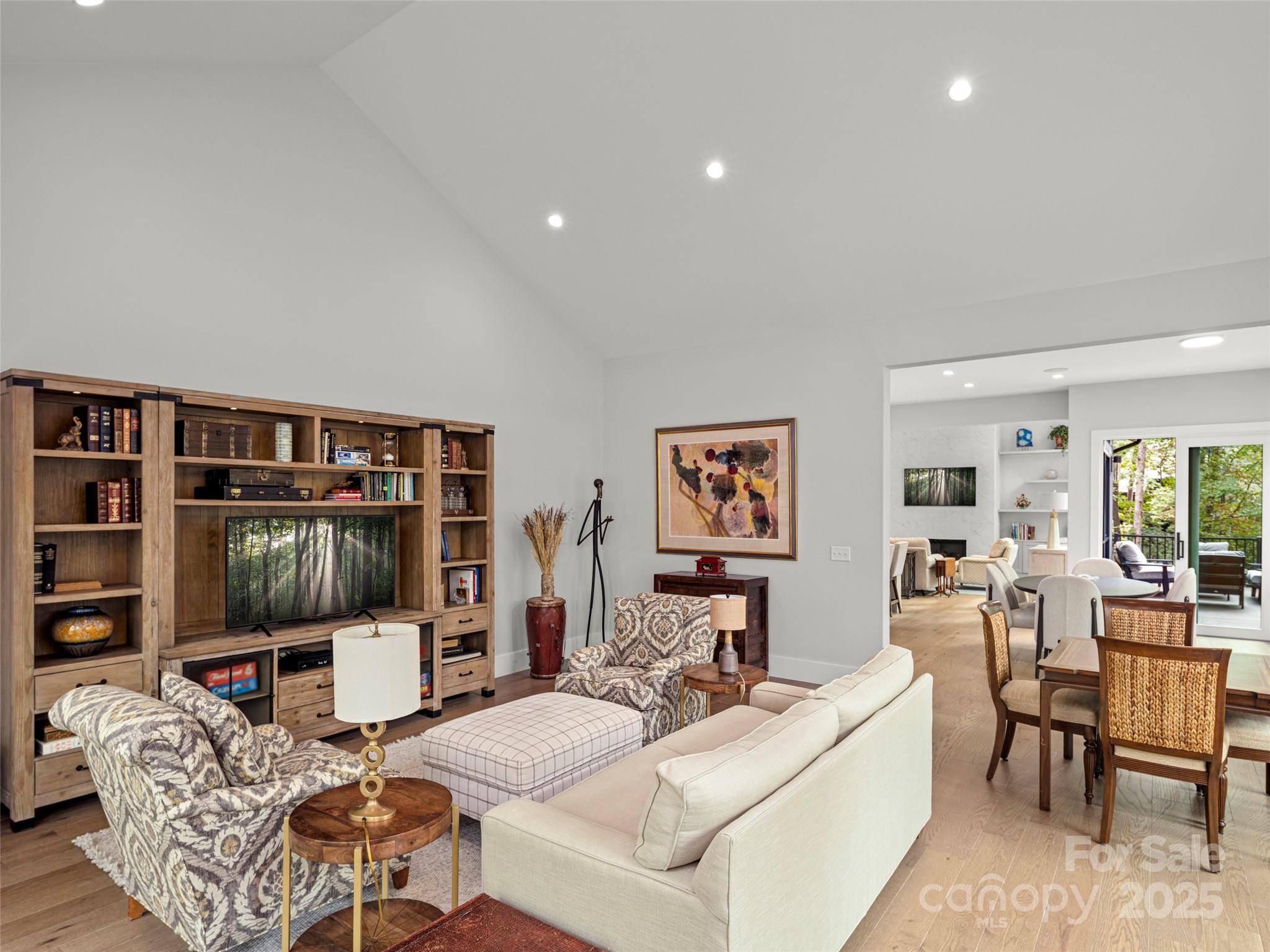 1565 Country View Way Arden, NC 28704 - Photo 17 of 31 a living room with furniture a flat screen tv and a floor to ceiling window