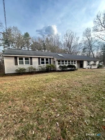 a view of backyard with wooden fence and large trees