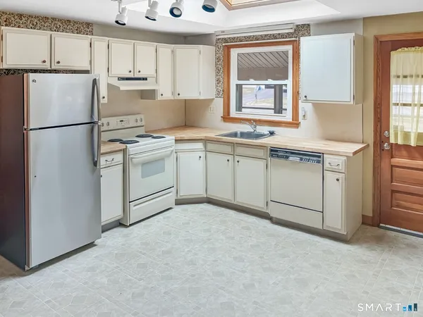 a kitchen with white cabinets and white appliances