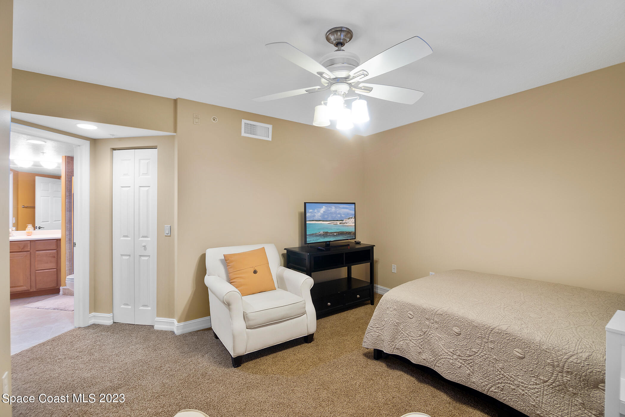 134 Starboard Lane, Unit 306 Merritt Island, FL 32953 - Photo 27 of 42 a bedroom with a bed and a chandelier