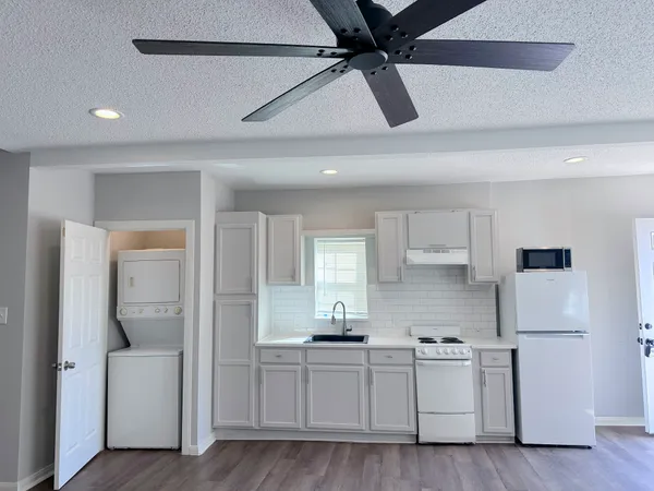 a kitchen with white cabinets and refrigerator