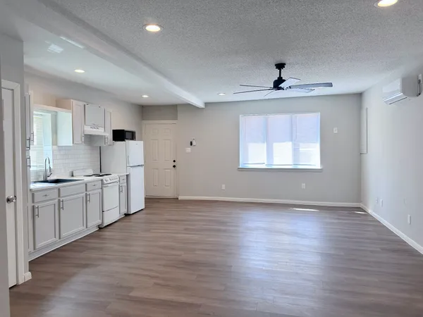 a large kitchen with stainless steel appliances a large counter top a sink and a window