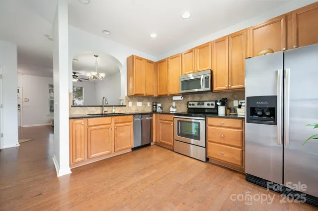 a kitchen with stainless steel appliances granite countertop a refrigerator sink and cabinets