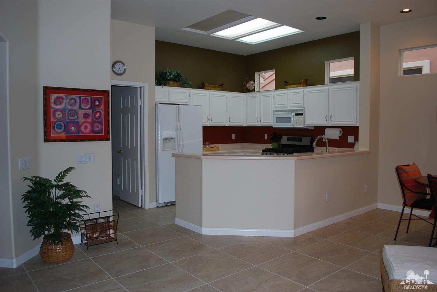 78082 Hunter Point Road Palm Desert, CA 92211 - Photo 15 of 38 a kitchen with stainless steel appliances kitchen island granite countertop a refrigerator and a stove