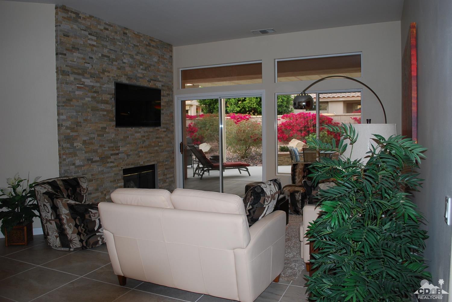 78082 Hunter Point Road Palm Desert, CA 92211 - Photo 5 of 38 a living room with furniture a flat screen tv and a fireplace