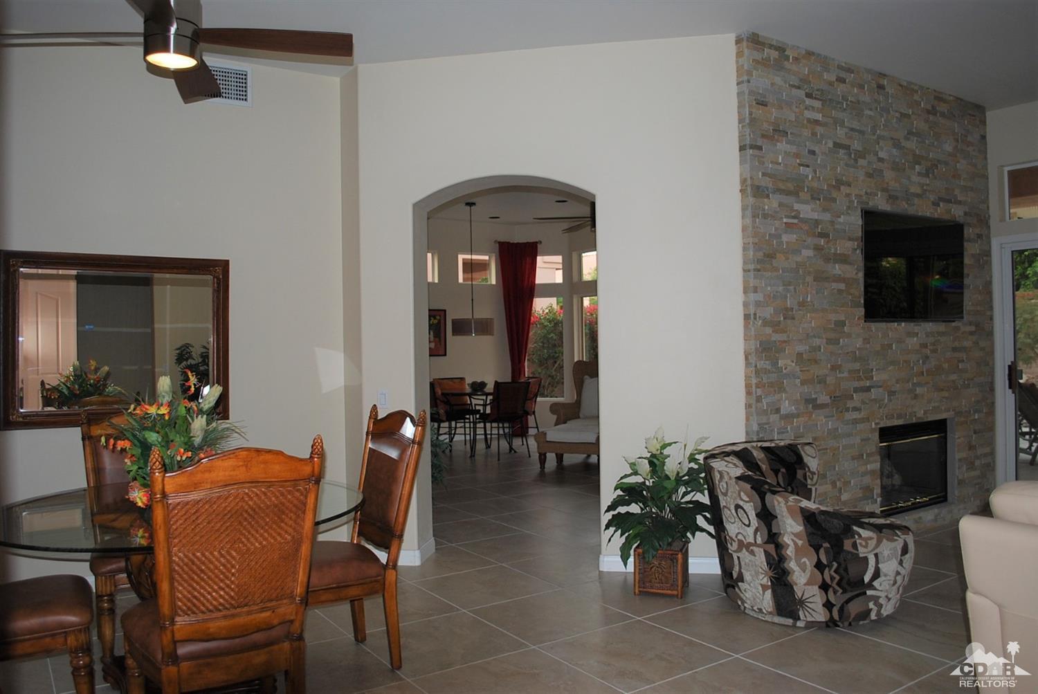 78082 Hunter Point Road Palm Desert, CA 92211 - Photo 6 of 38 a dining room with furniture a fireplace and potted plants