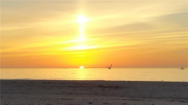 a view of a lake with sunset in the background