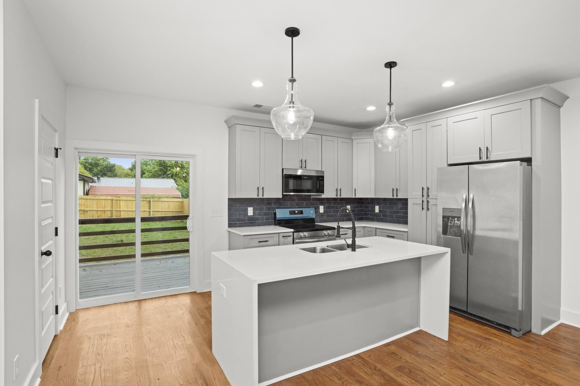 507 Demoss Street, Unit 110 Gallatin, TN 37066 - Photo 5 of 27 a kitchen with kitchen island a sink stainless steel appliances and white cabinets