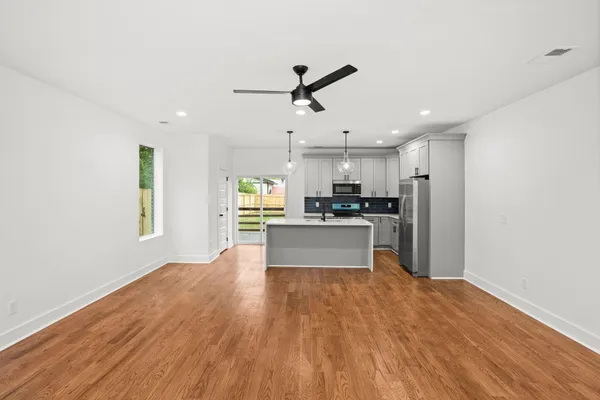 a large kitchen with cabinets wooden floor and stainless steel appliances