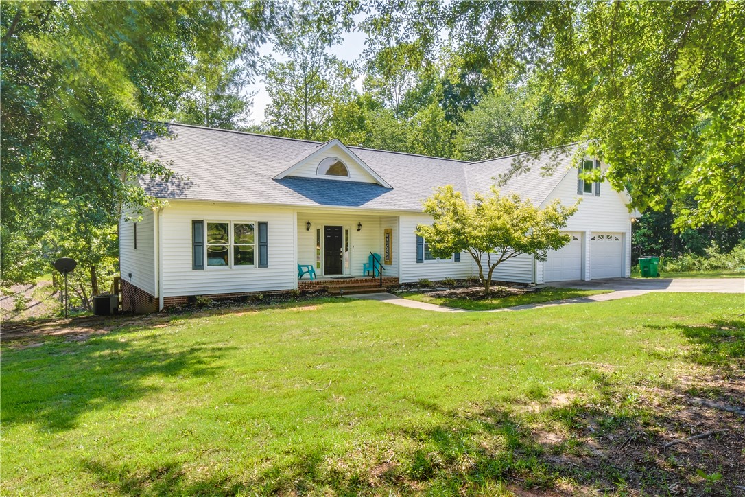 206 Petty Road Seneca, SC 29672 - Photo 48 of 48 A classic facade with a covered entry and attached garage, nestled among mature trees.
