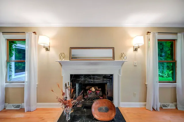 a living room with furniture a wooden floor and next to a window