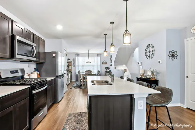 a kitchen with a sink a stove and chairs