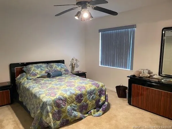a bedroom with a bed and a chandelier fan