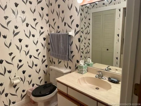 a bathroom with a sink and mirror with toilet