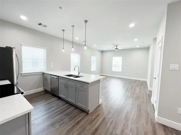 a kitchen with stainless steel appliances granite countertop a sink a stove a refrigerator and a large window