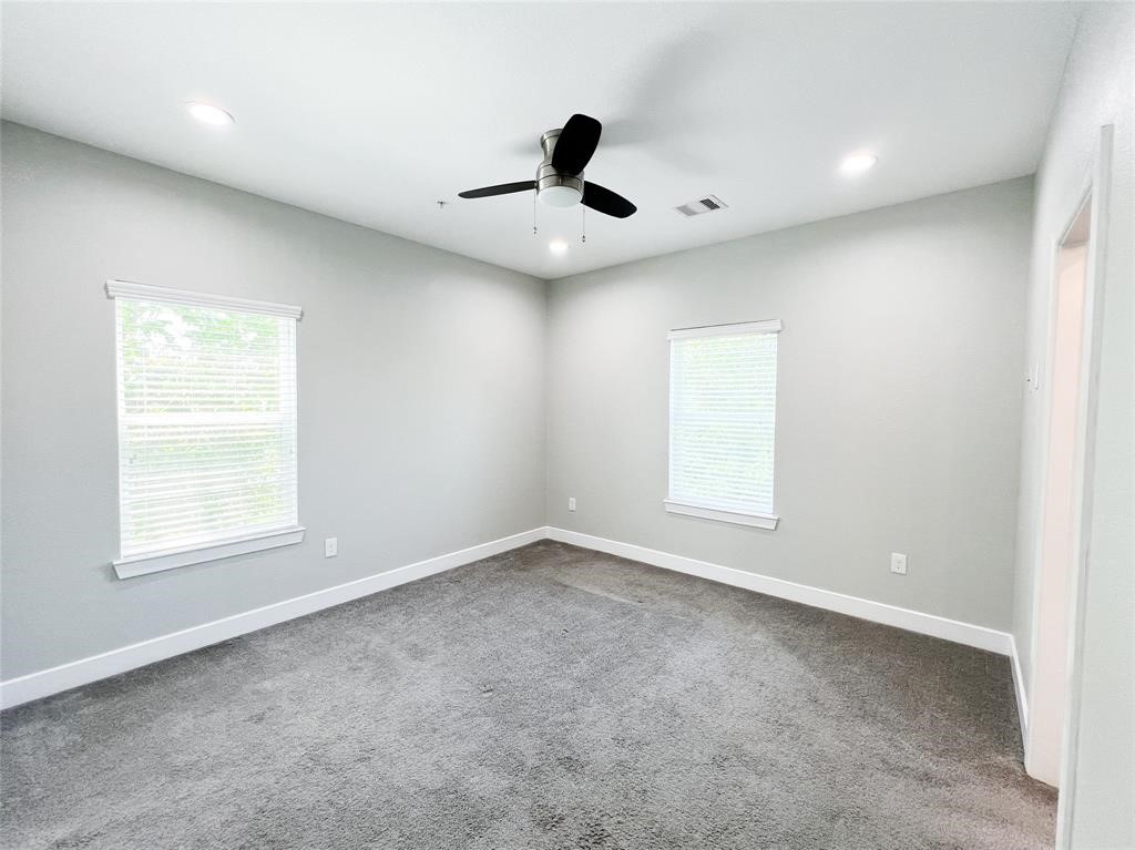 144 West 5th Street, Unit B Kemah, TX 77565 - Photo 11 of 22 an empty room with a window and a ceiling fan