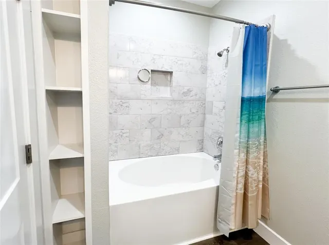 a bathroom with a bathtub and shower