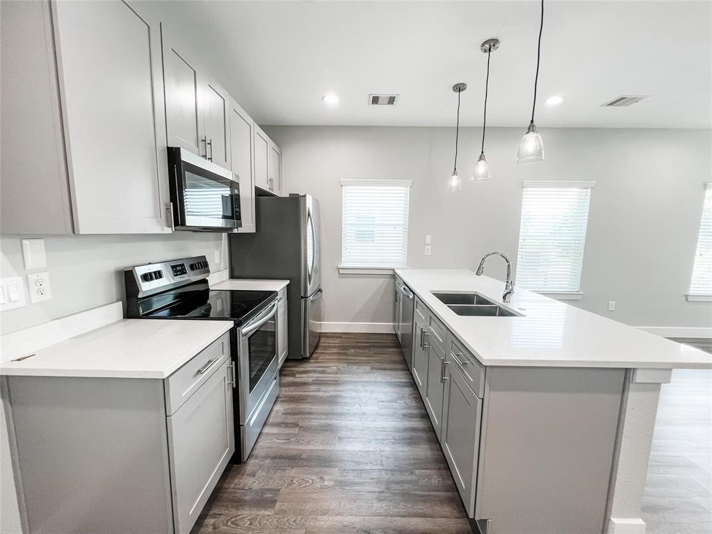 144 West 5th Street, Unit B Kemah, TX 77565 - Photo 3 of 22 a kitchen with a sink stove and refrigerator