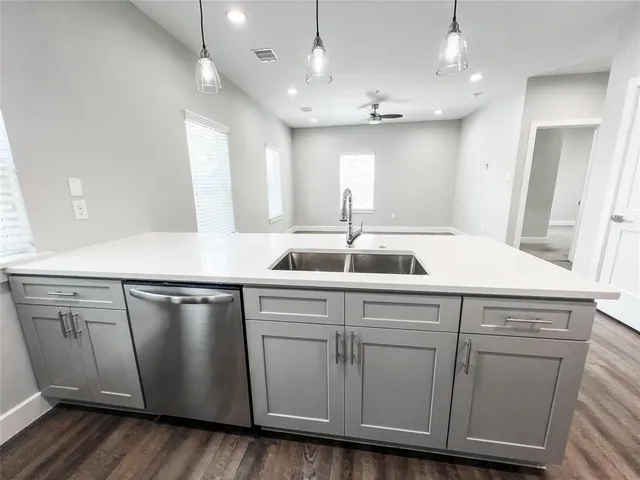 a kitchen with a sink and wooden floor