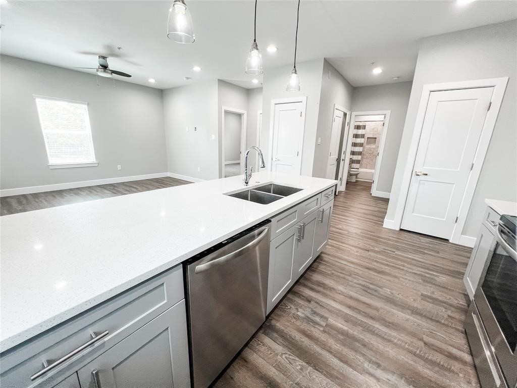 144 West 5th Street, Unit B Kemah, TX 77565 - Photo 5 of 22 a large white kitchen with a large island oven a sink dishwasher and a large refrigerator