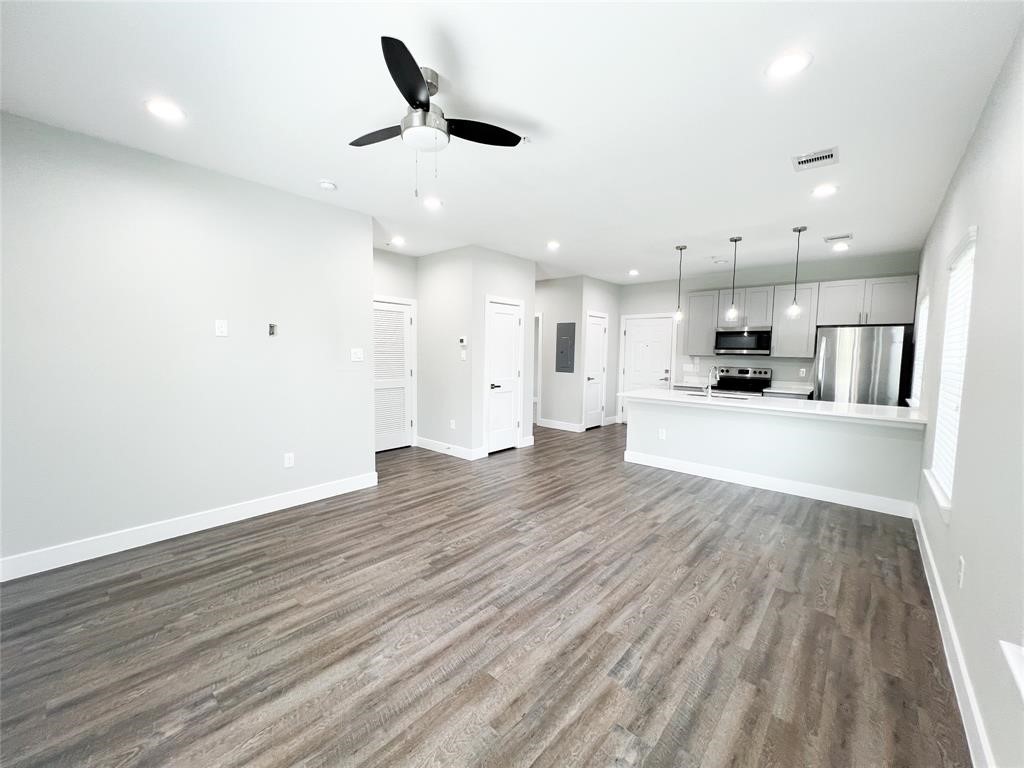 144 West 5th Street, Unit B Kemah, TX 77565 - Photo 9 of 22 an empty room with wooden floor and windows