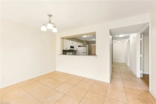 a view of a hallway with wooden floor and chandelier