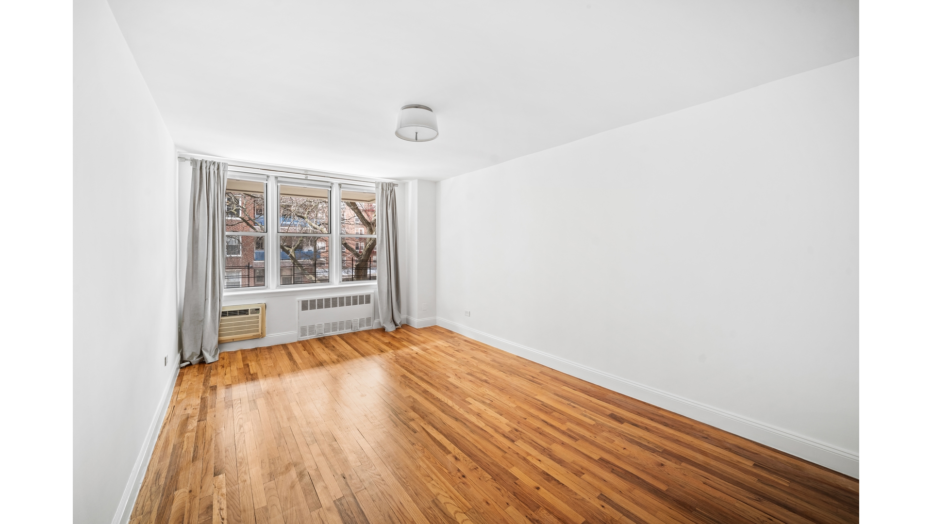 415 Argyle Road, Unit 2/3L Brooklyn, NY 11218 - Photo 13 of 23 a view of an empty room with wooden floor and a window