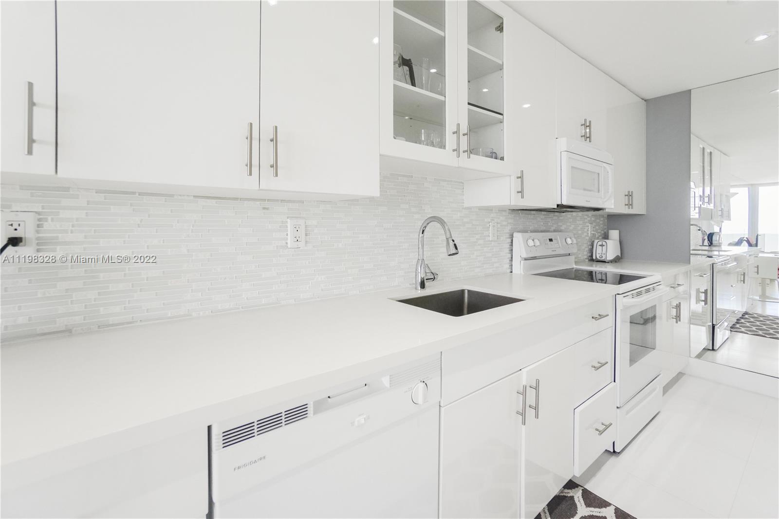 100 Lincoln Road, Unit 646 Miami Beach, FL 33139 - Photo 13 of 21 a kitchen with white cabinets and white appliances