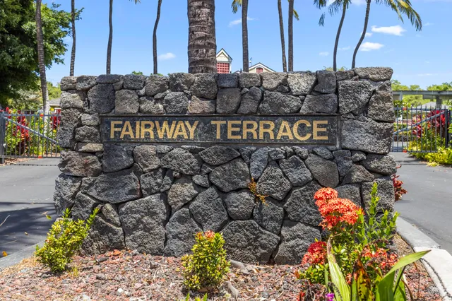 a street sign on a wall next to a road