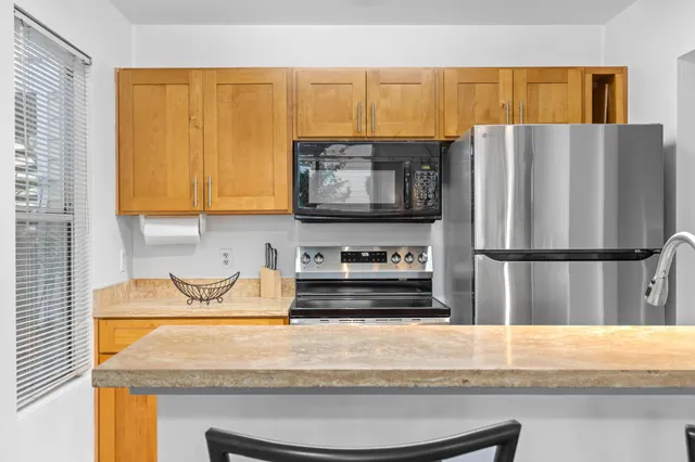 a kitchen with stainless steel appliances granite countertop a sink stove and refrigerator