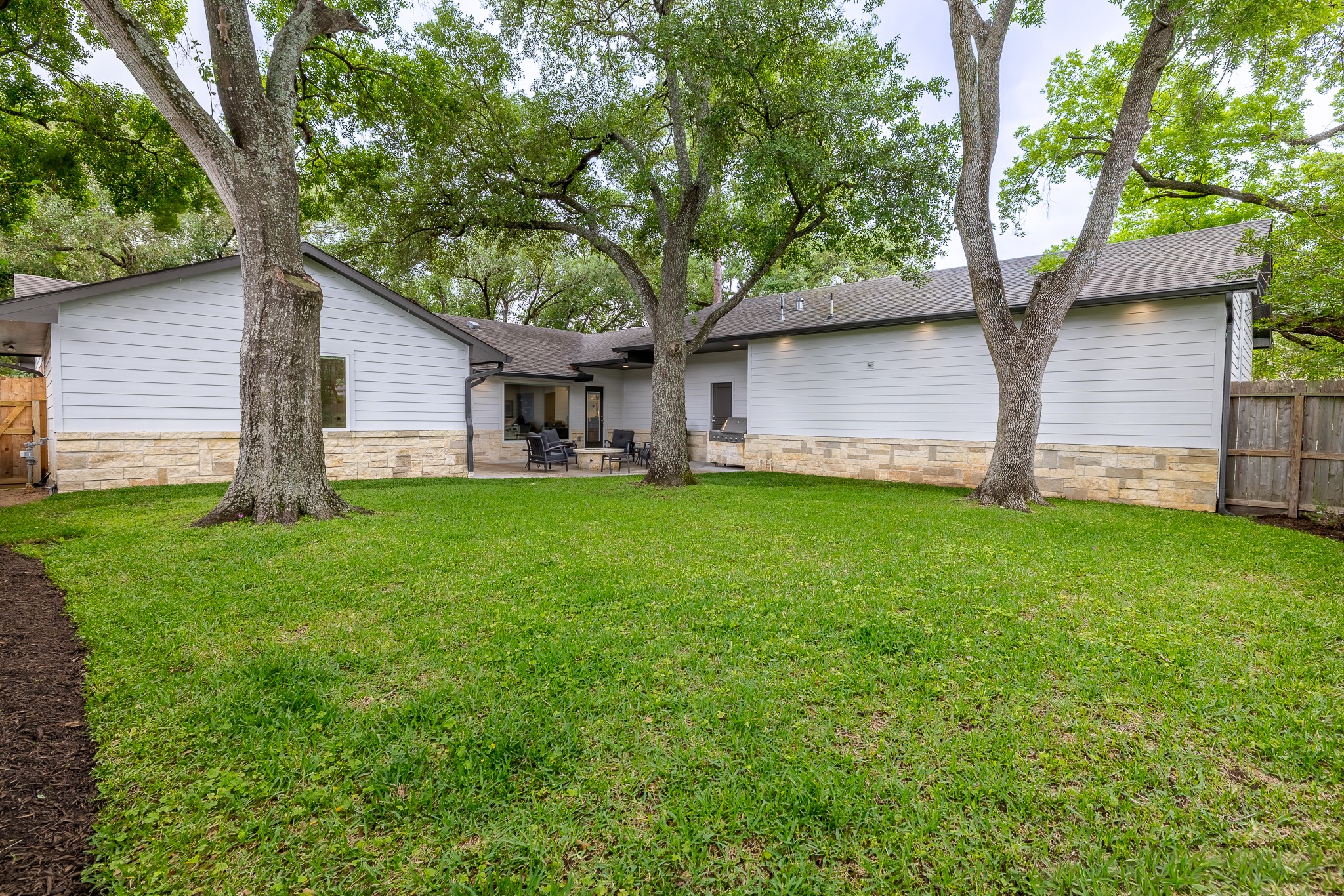 5230 Redstart Street Houston, TX 77035 - Photo 27 of 30 Lush backyard with mature trees, full sprinkler system, and automated mosquito misting system