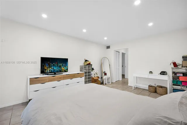 a bedroom with furniture and a flat screen tv