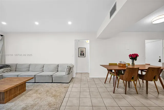 a living room with furniture and a dining table with kitchen island