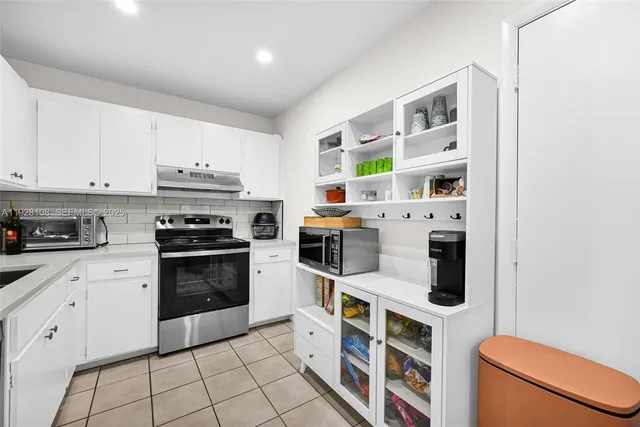 a kitchen with stainless steel appliances a stove a microwave and a cabinets