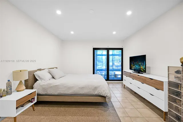 a spacious bedroom with a bed and a flat screen tv