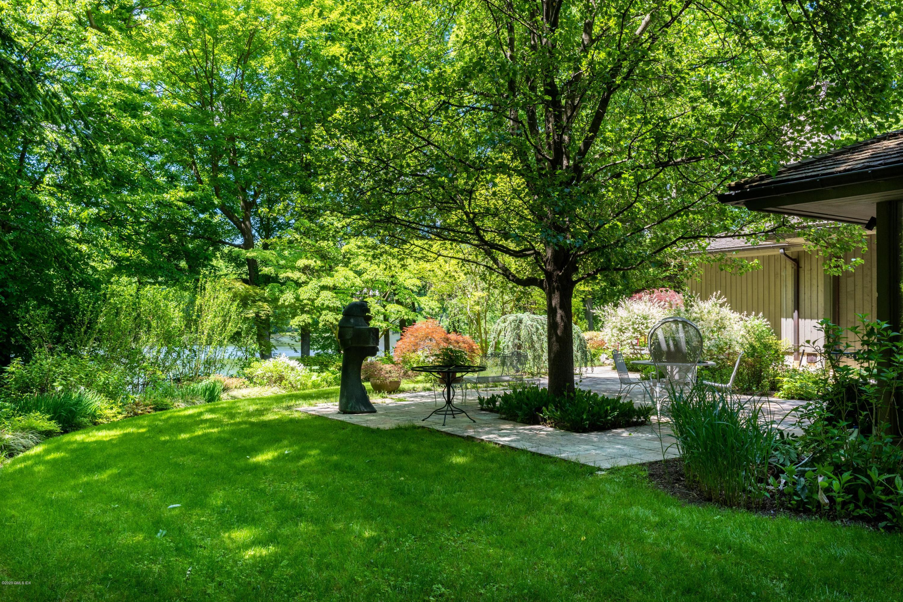51-0 Burying Hill Road Greenwich, CT 06831 - Photo 27 of 47 a view of a garden with plants and a bench
