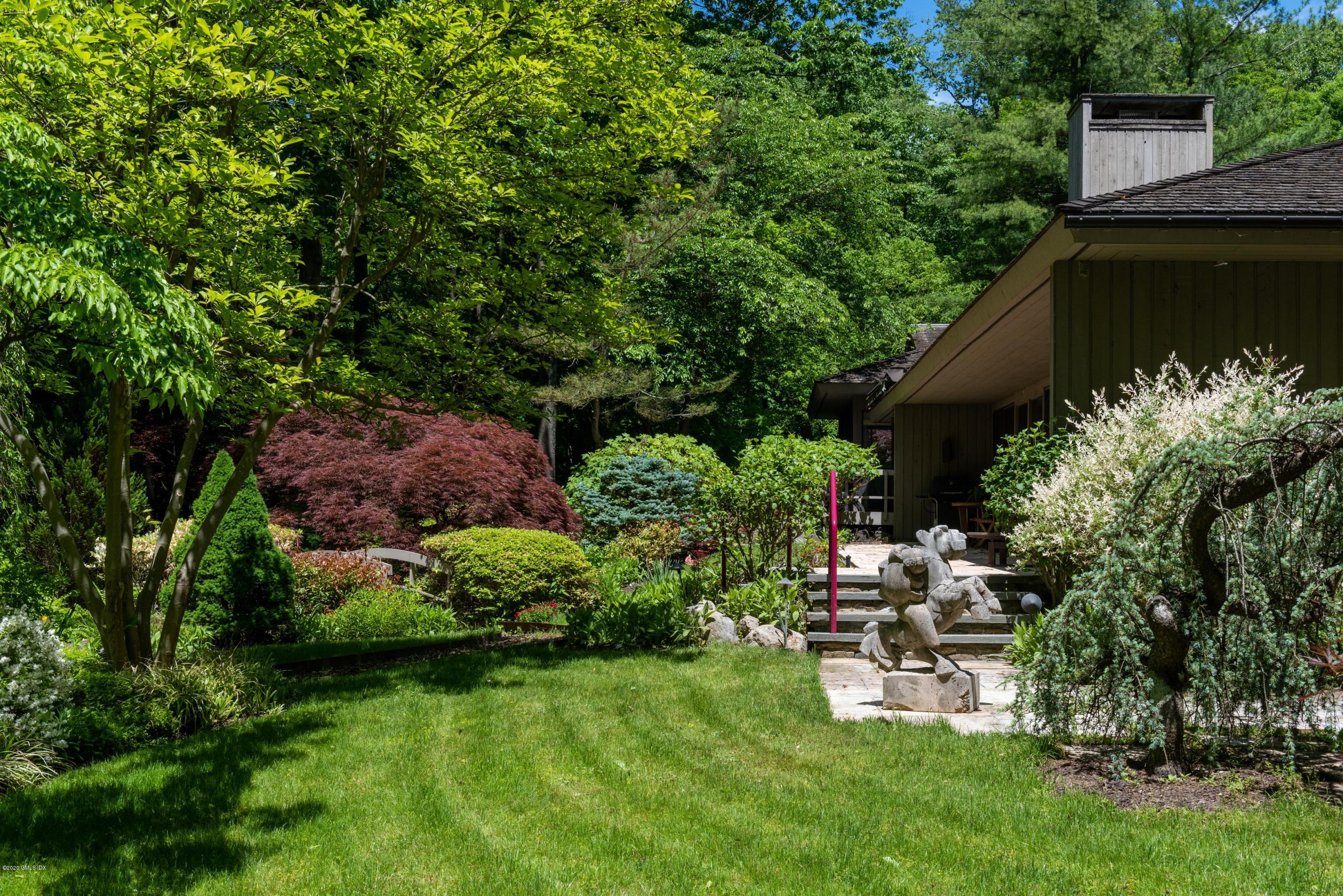 51-0 Burying Hill Road Greenwich, CT 06831 - Photo 4 of 47 a garden with a bench and trees